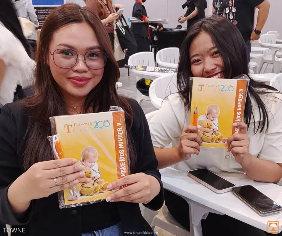 Filipino nursing student at OET Fair 2026 holding OET materials Towne Kids event